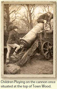Picture of the Old Russian Cannon at the top of Town Wood, overlooking Congleton Park. It shows the cannon coming away from the gun carriage, and two young boys playing on it, dressed in short trousers and with caps on their heads.